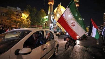Demonstrators wave Iran's flag and a Palestinian flag as they gather at Palestine Square in Tehran on April 14, 2024, after Iran launched a drone and missile attack on Israel.  Atta Kenare | Afp | Getty Images