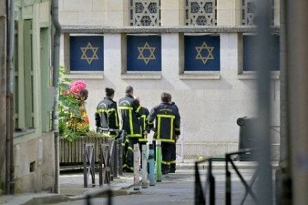 Fire brigade members stand by a synagogue in the Normandy city of Rouen where French police have killed earlier an armed man who was trying to set fire to the building (Picture: Getty)