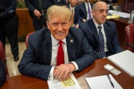 Former President Donald Trump (center) sits with lawyers while he attends his trial at Manhattan Criminal Court on Tuesday (Picture: AP)