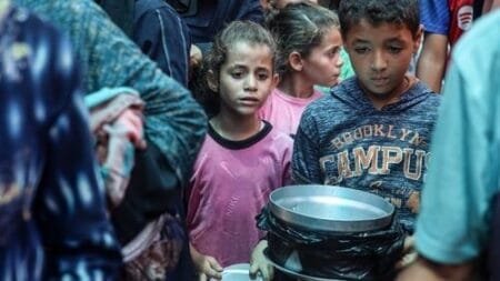 Children wait for food at a distribution centre in Deir-al-Balah