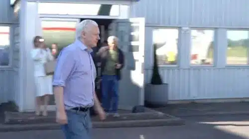 Julian Assange pictured before boarding a plane in London yesterday