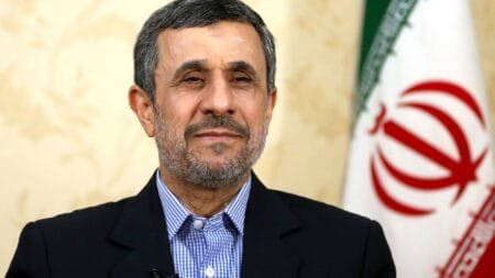 Mahmoud Ahmadinejad waves to the media as he arrives for a press briefing after submitting his application for the June 28 election in Tehran, Iran, Sunday, June 2, 2024