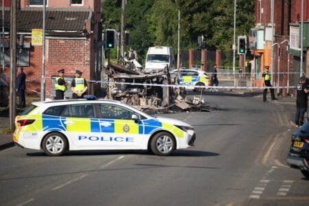 Police tape cordons off the remains of a burnt-out bus after the riots in Leeds (Getty Images)