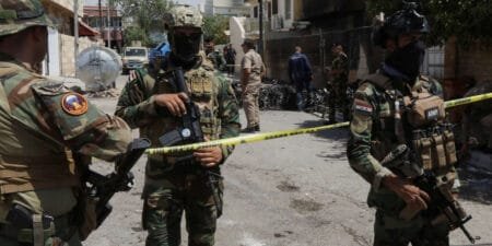 Members of Iraqi security forces stand near the debris of an armed drone shot down by Iraqs air defences in Kirkuk
