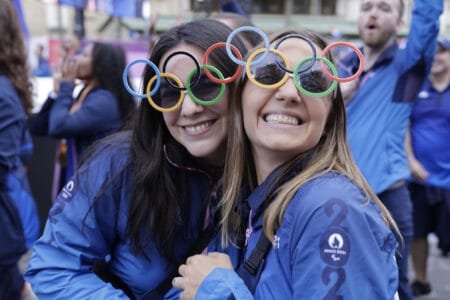 Volunteers pose with Olympic ring sunglasses at the parade. © Andre Pain, AFP