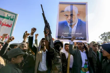 Supporters of Yemens Huthis chant slogans as they gather with a picture of Hamas slain leader Yahya Sinwar during a rally