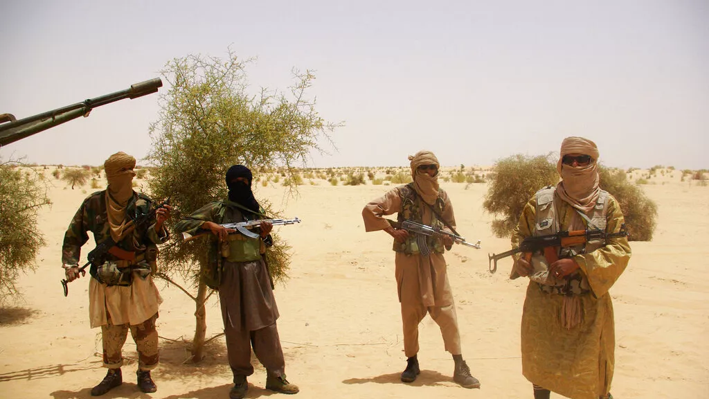 File In this Tuesday April 24 2012 file photo fighters from Islamist group Ansar Dine stand guard during a hostage handover in the desert outside Timbuktu Mali