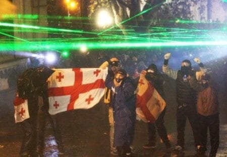 Protestors donned gas masks and held up the Georgian flag facing police officers Picture Reuters