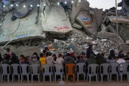Palestinians sit at a large table surrounded by the rubble of destroyed homes and buildings as they gather for iftar, the fast-breaking meal, on the first day of Ramadan in Rafah, southern Gaza Strip, on March 1.Abdel Kareem Hana/The Associated Press
