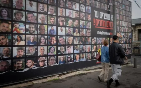 People walk past pictures of the hostages held by Hamas in Gaza in Jerusalem January 12 2025