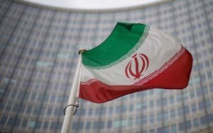 A national flag of Iran waves in front of the building of the International Atomic Energy Agency, IAEA, in Vienna, Austria, Dec. 17, 2021. (AP Photo/Michael Gruber, File)