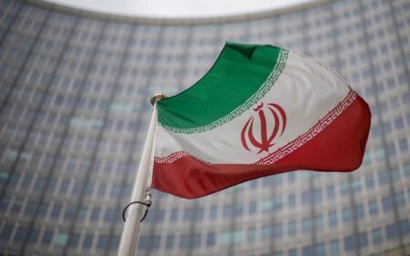 A national flag of Iran waves in front of the building of the International Atomic Energy Agency, IAEA, in Vienna, Austria, Dec. 17, 2021. (AP Photo/Michael Gruber, File)