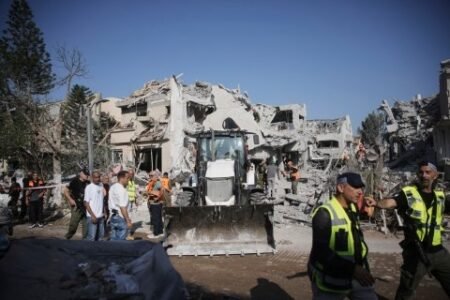 Israeli emergency responders inspect a site hit by a missile fired from Iran south of Tel Aviv (Picture: AFP)